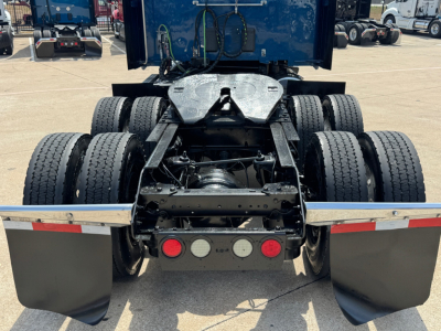 Kenworth truck rear showing fifth wheel and dual rear axles with mudflaps and lights; no visible model text or stickers readable.