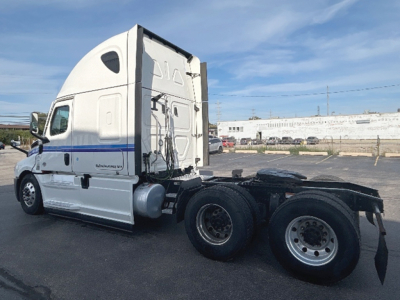 Freightliner Cascadia126 semi-truck tractor side view showing sleeper cab and dual rear axles with wheels.