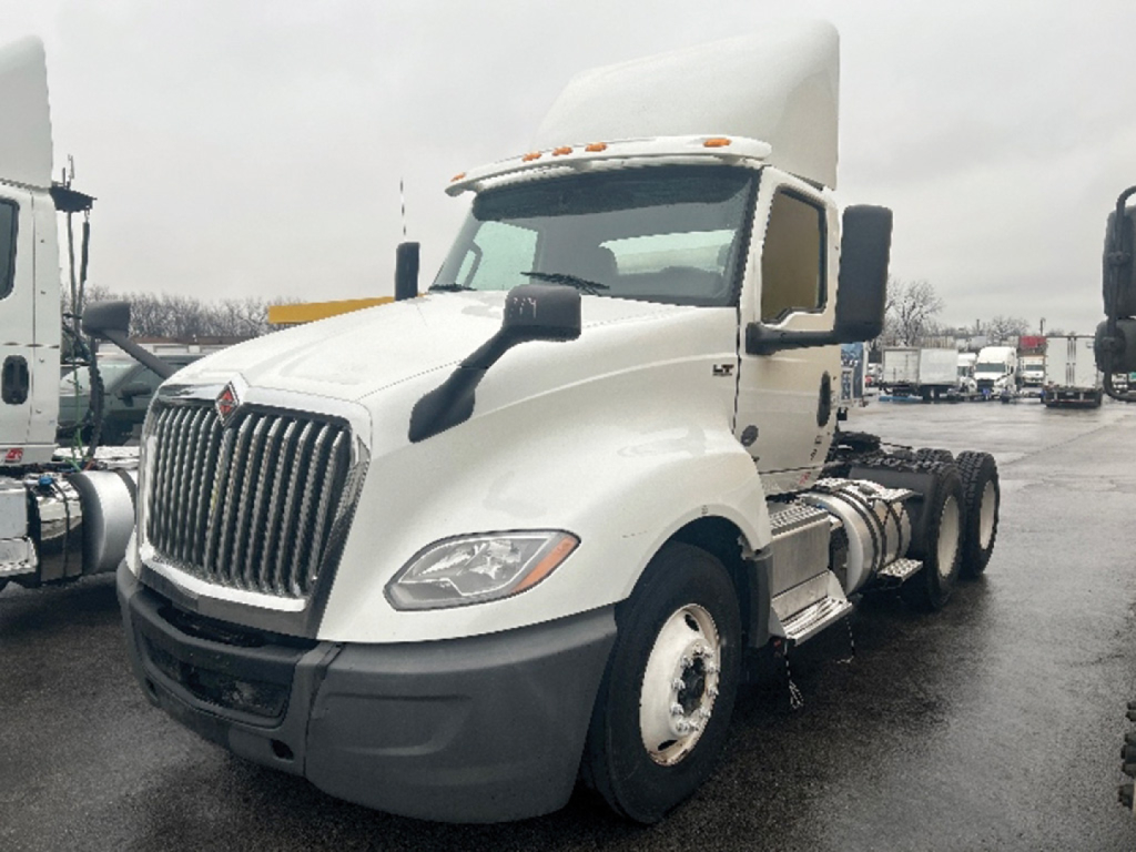 International LT625 daycab truck showing front and side view with white cab and black bumper, dual rear axles, no trailer.