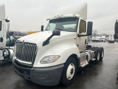 International LT625 daycab truck showing front and side view with white cab and black bumper, dual rear axles, no trailer.