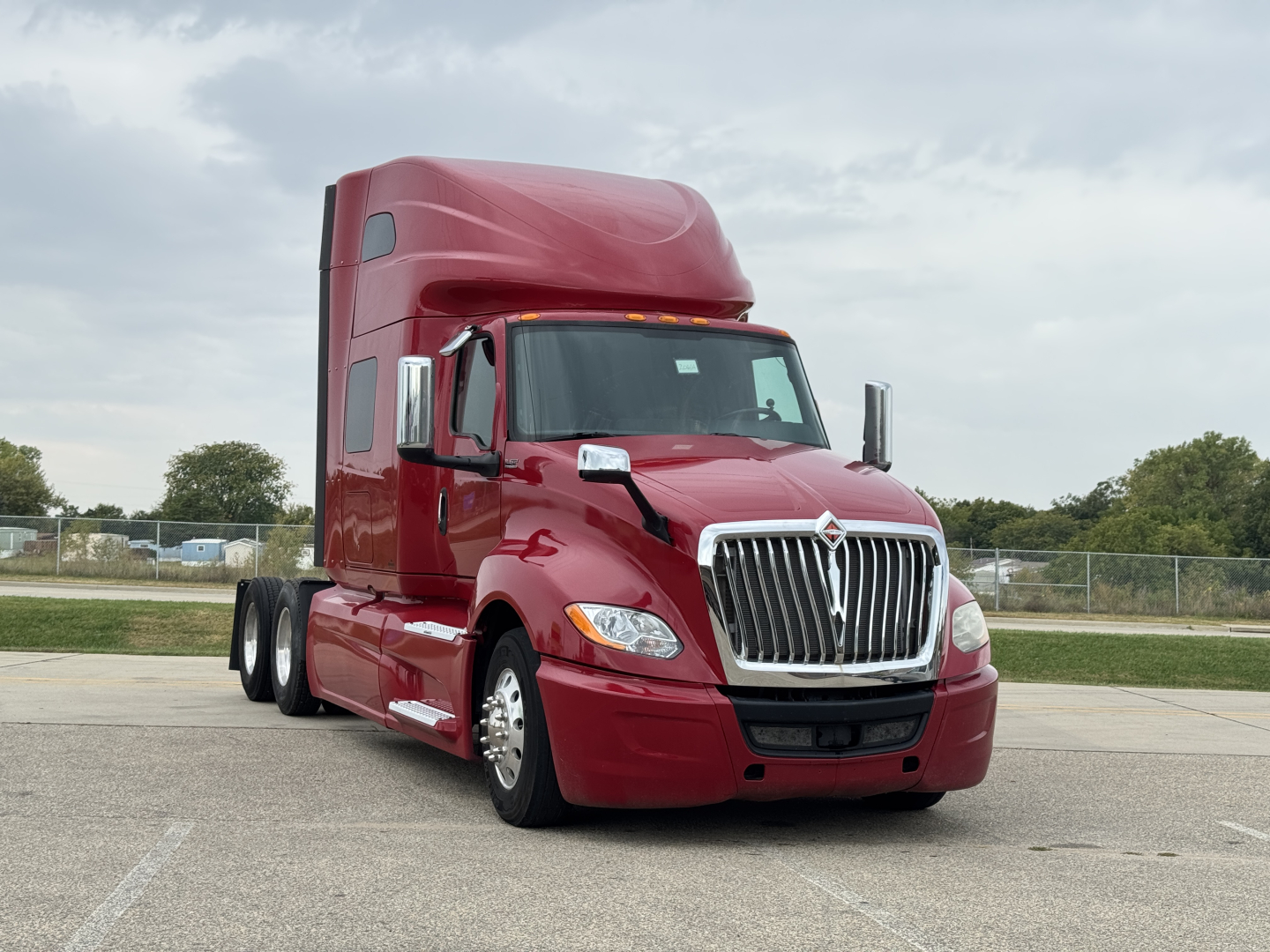 Truck cab exterior, red 2018 International LT625 sleeper, three-axle tractor with tall sleeper, chrome grille and headlights visible.