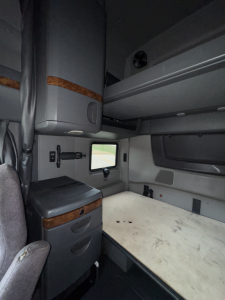 Cab interior of a 2018 International LT625 sleeper showing bunk bed area and storage cabinet.
