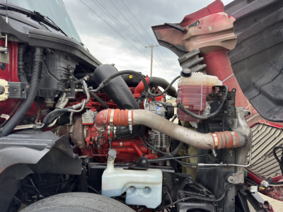 International LT625 engine bay showing red engine block, hoses, coolant reservoir, and intake components.