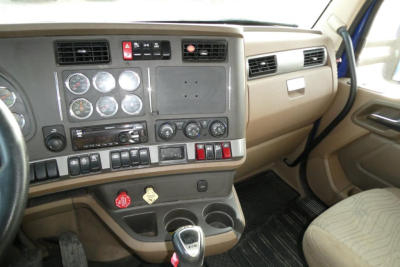 Kenworth T680 dash and center console showing gauges and controls in a truck interior.