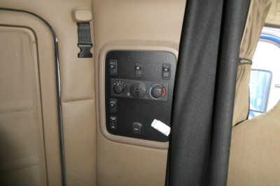 Kenworth T680 interior dash panel showing climate controls and window switches in beige cab.