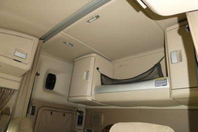 Kenworth T680 sleeper cab interior featuring overhead storage compartments and a netted side shelf.
