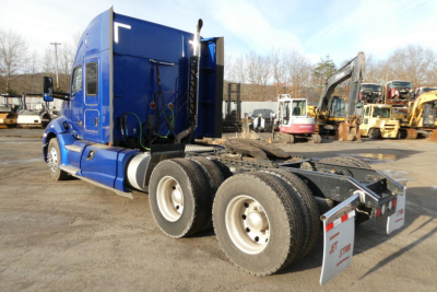 Kenworth T680 tractor cab and chassis showing side view with blue paint and dual rear axles.
