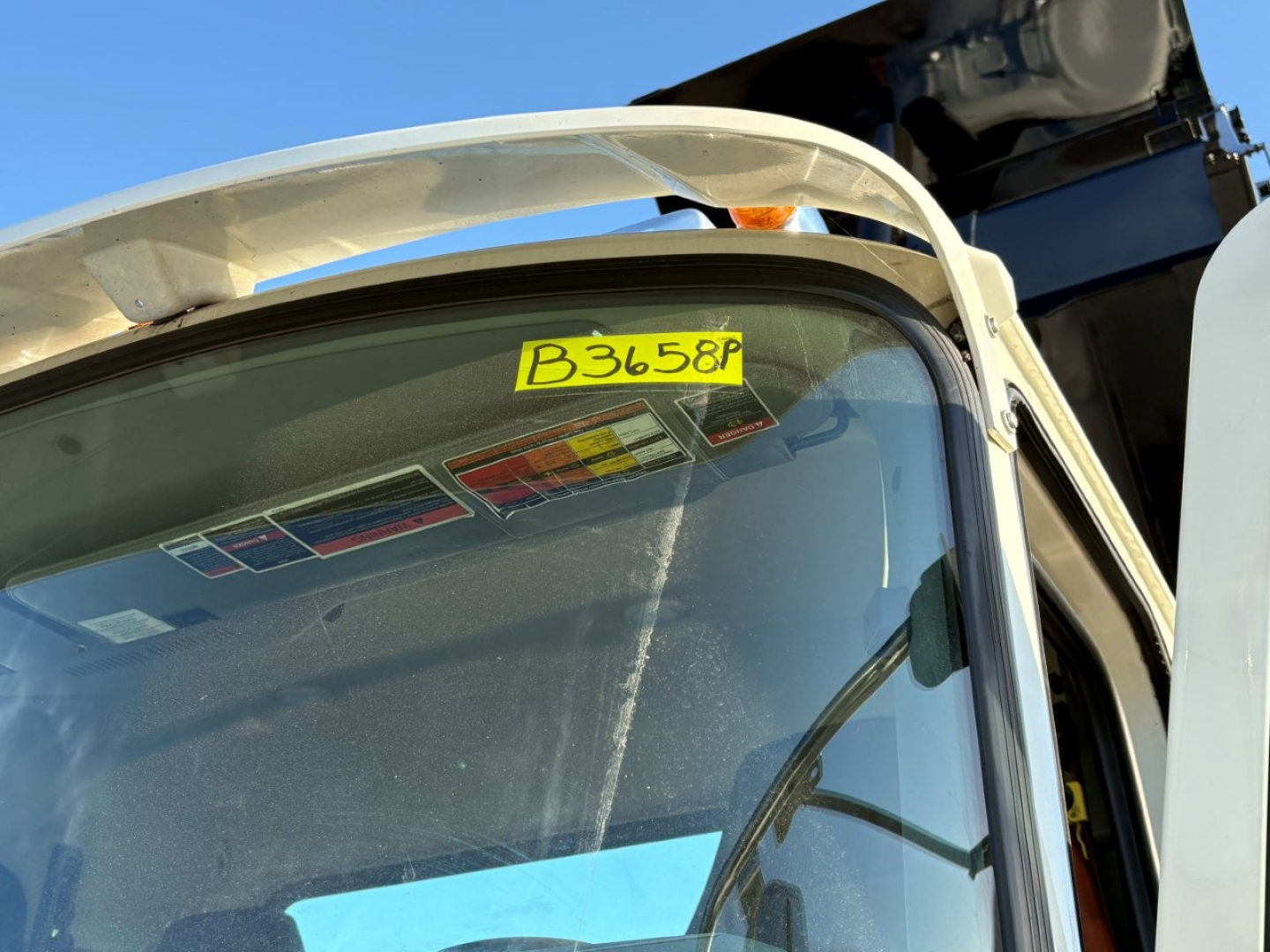 Truck cab windshield with yellow B3658P stock tag visible.