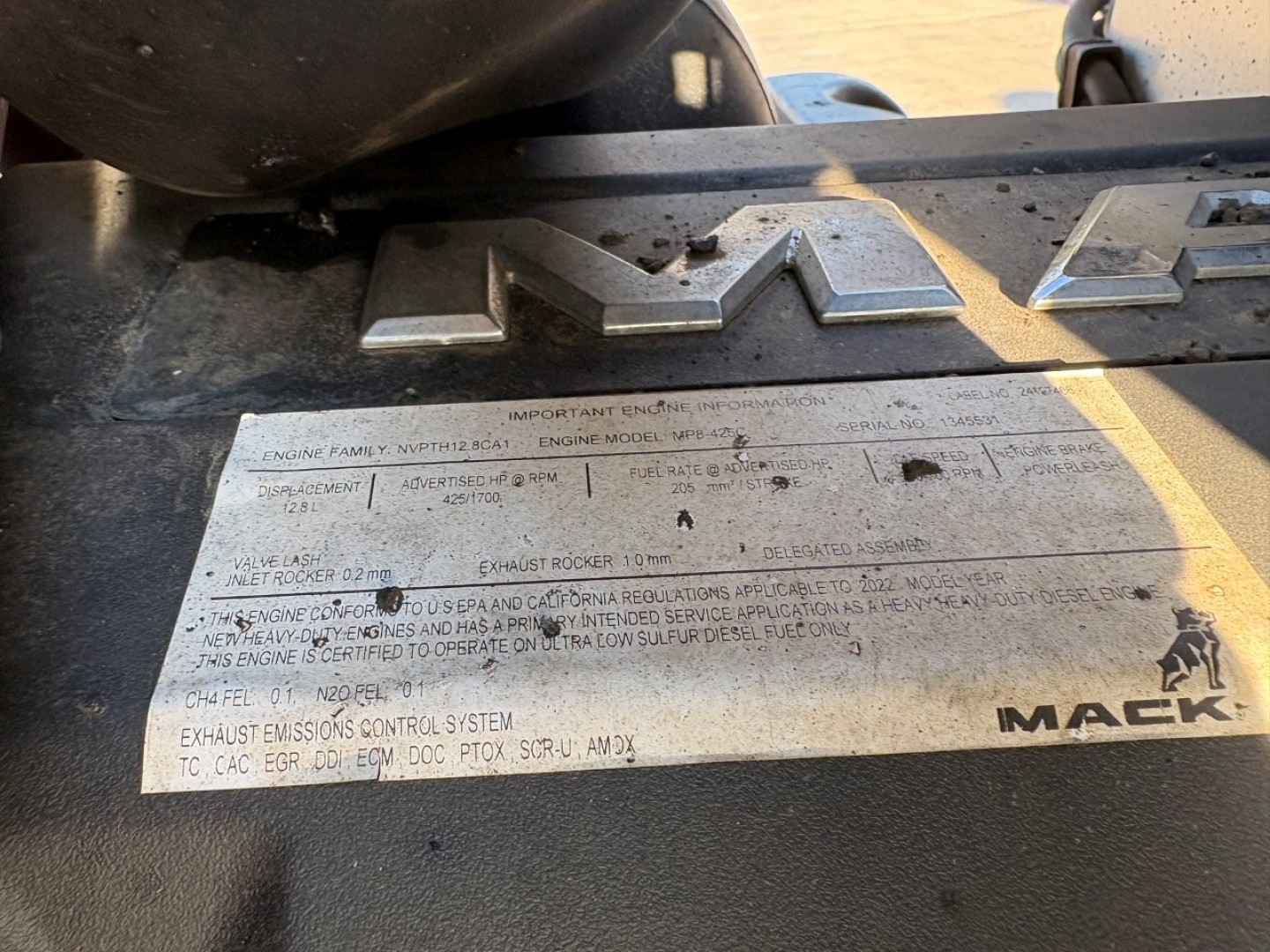 Mack engine bay plate with VIN and specs on a Mack GR84F truck, showing large 'M A C K' lettering and model badge.