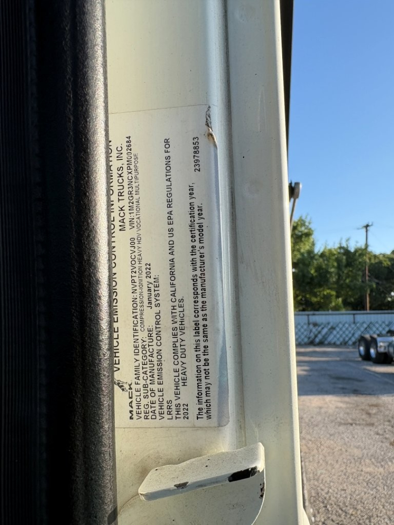 Vehicle information label on Mack GR84F side door area with small printed text including VIN and regulatory statements.
