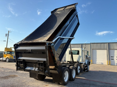Truck dump bed on a Mack GR84F chassis with raised hydraulic dump bed and triple-axle configuration visible.