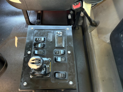 Panel of truck cab showing multiple switches and a toggle knob in a Mack GR84F interior image.
