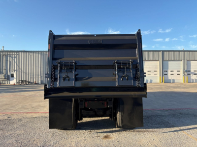 Dump truck bed of a 2023 Mack GR84F viewed from rear, showing dump body and dual rear wheels.