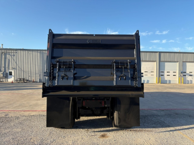 Dump truck bed of a used 2023 Mack GR84F viewed from rear showing lifted tailgate and rear tires.