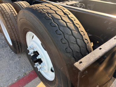 Mack GR84F dump truck rear wheel and chassis showing dual rear tires and wheel hub with bolts.