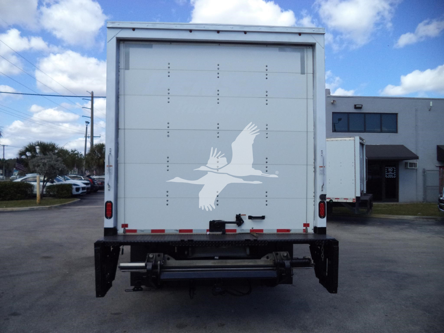 Isuzu NPR HD box truck rear showing white bird logo on back door and taillights