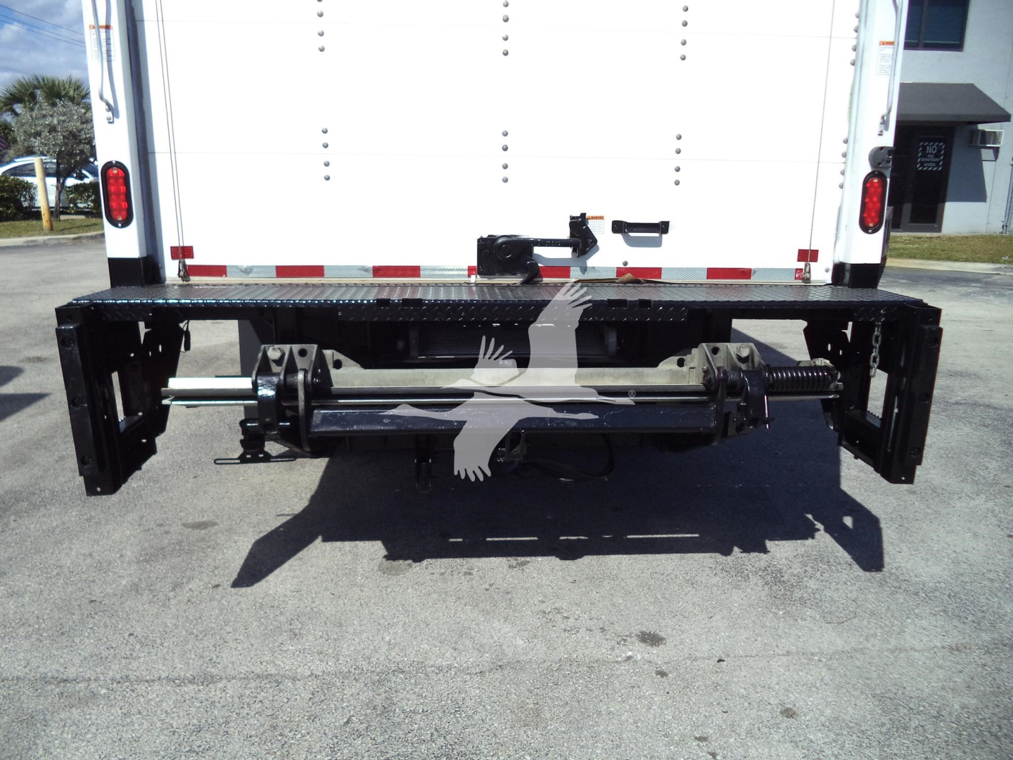 Isuzu NPR HD truck rear with chassis and hitch, showing mounting bars and underbody components; no legible text visible.