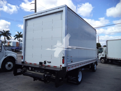 Box truck rear/side view showing cargo box with Isuzu NPR HD style; white box trailer with black rear bumper and taillights; visible wheel and chassis.