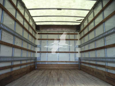 Interior cargo area of a 2020 Isuzu NPR HD box truck showing empty wooden floor and metal side rails.