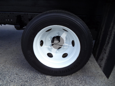 Isuzu NPR HD box truck wheel close-up showing white steel rim and tire with visible tread.