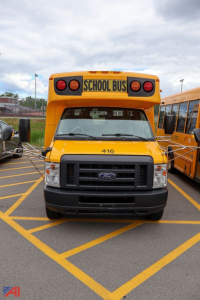 Ford E-Series school bus front view showing yellow body, black grille, and 'SCHOOL BUS' sign on top. Number '416' on the hood.