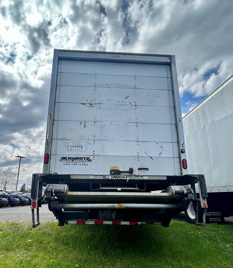 Freightliner M2 106 medium duty box truck rear view showing liftgate and bumper components.