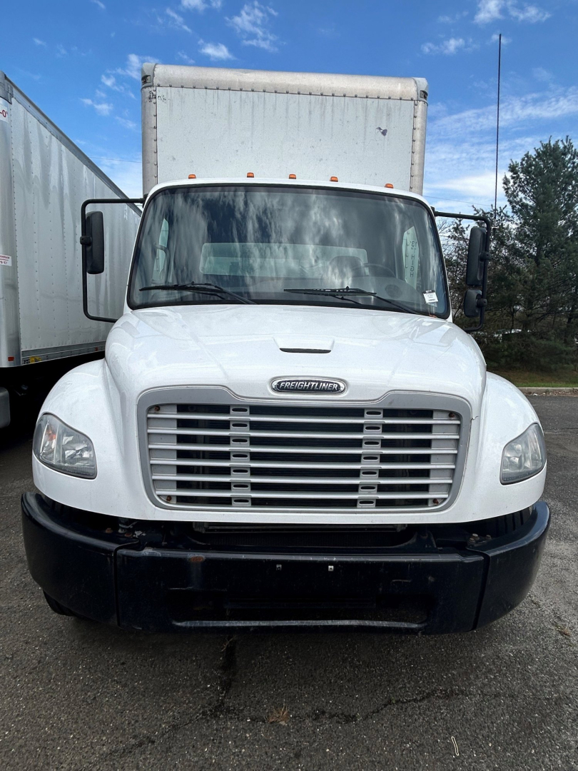 Freightliner M2 106 front view showing large grille, headlights, and white cab with black bumper.