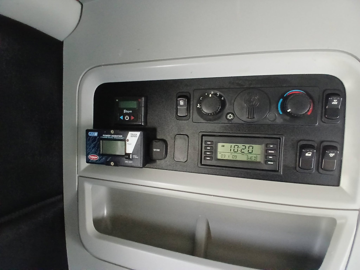 Dashboard area of a Kenworth truck cab with climate controls, radio, and a card reader. Visible text includes a digital display showing 10.2? and various control labels.