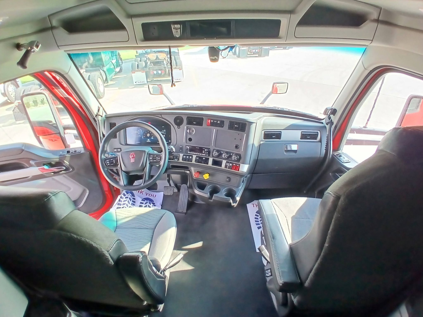Kenworth T680 truck interior cabin dash and steering wheel view from driver seat showing instrument cluster and center console.