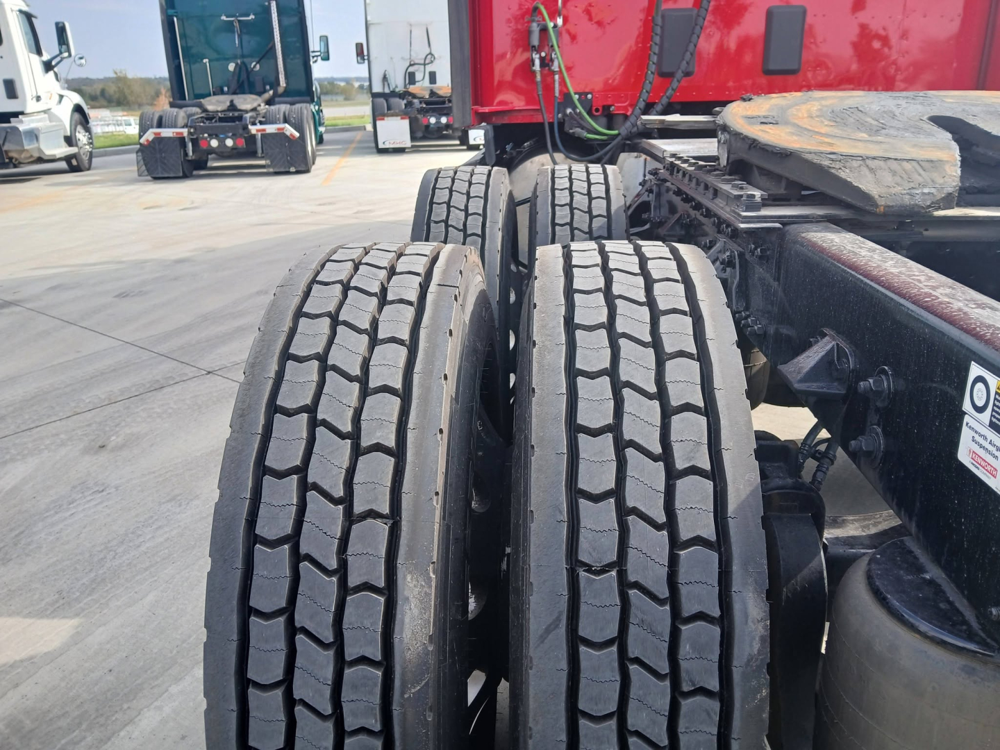 Kenworth T680 rear dual tires view showing truck frame and fifth wheel in background.
