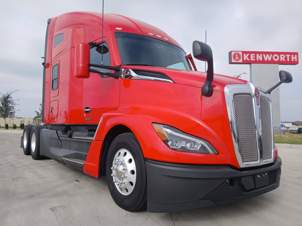 Kenworth T680 tractor with red cab and chrome grille, front-left view.