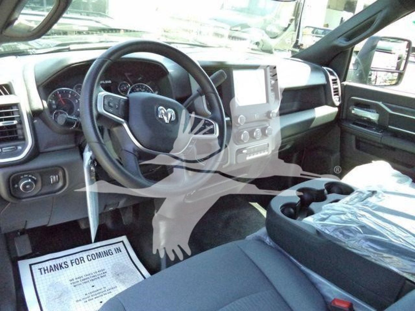Ram 1500/5500 interior shown with steering wheel, dash, large touchscreen, center console, and front passenger seat in view.