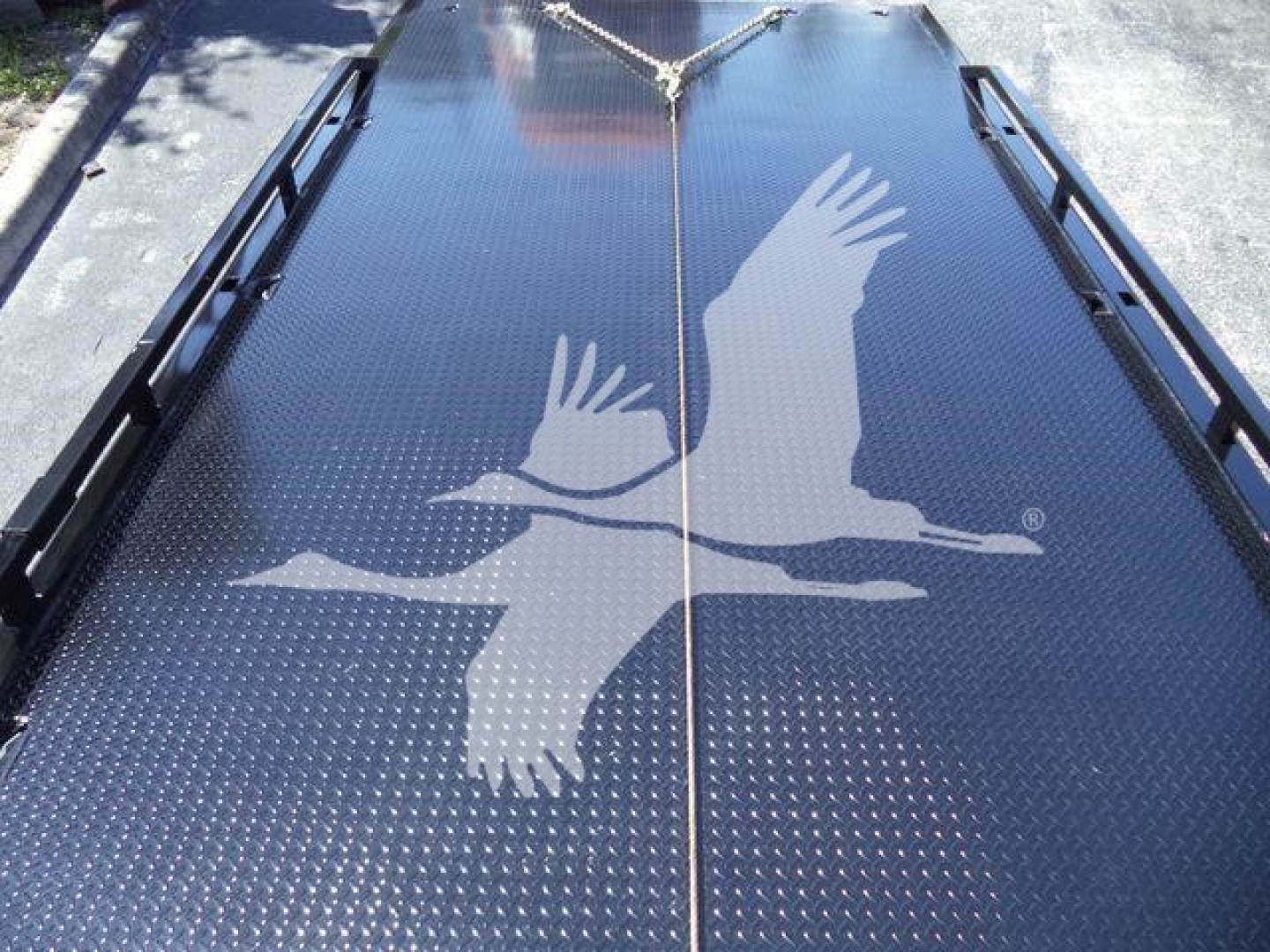 Ram 5500 rollback truck bed with a large graphic of two birds in flight on the diamond plate surface.