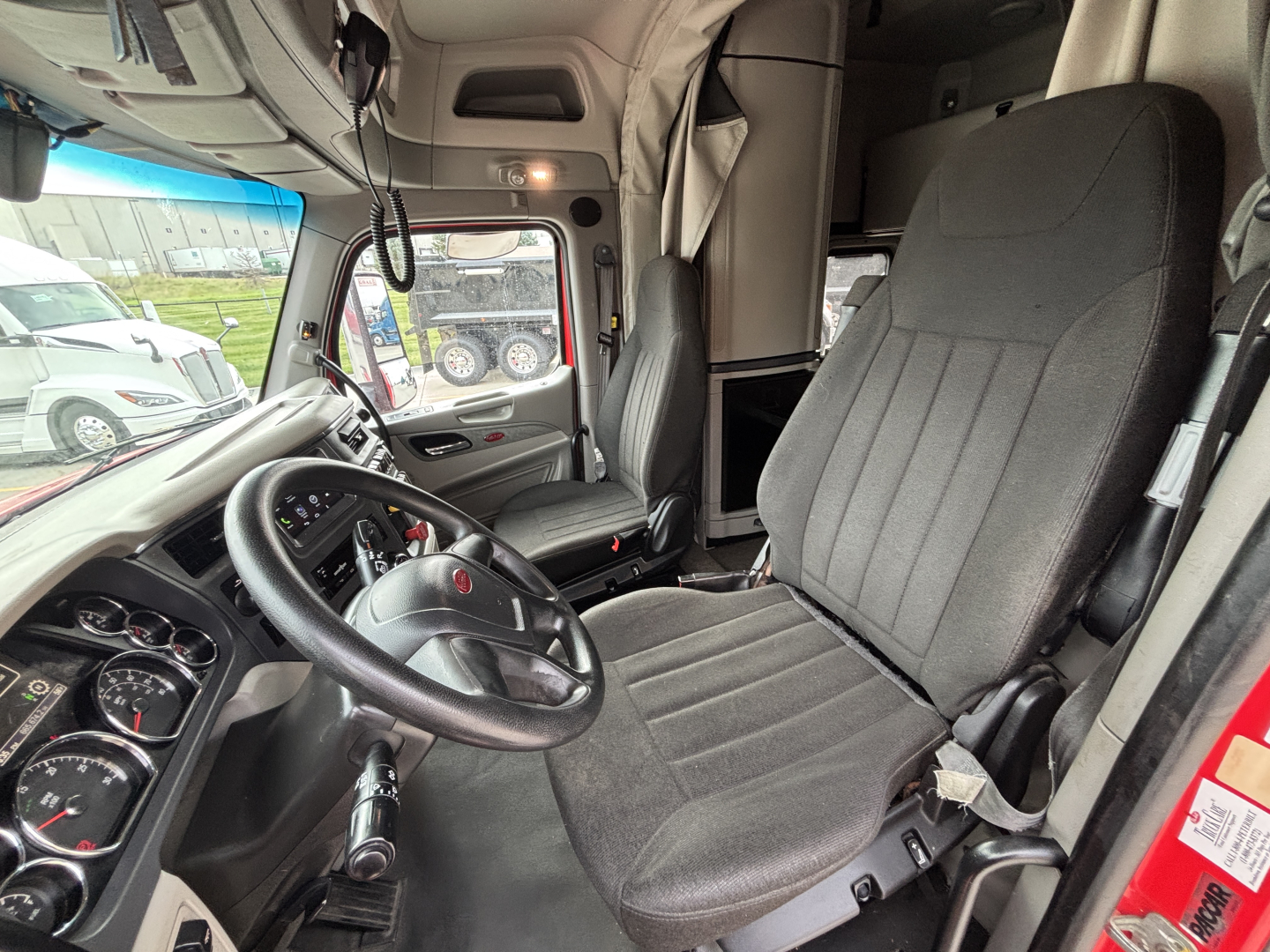 Peterbilt 579 truck interior cab view with steering wheel, driver seat, and dashboard gauges visible.