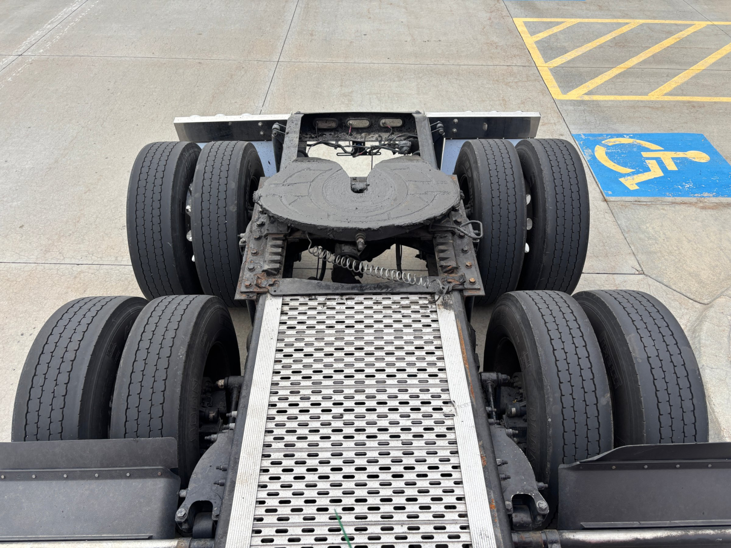 Peterbilt 579 chassis view showing rear dual axles with six wheels and aluminum access step, cabless sleeper configuration visible from above.