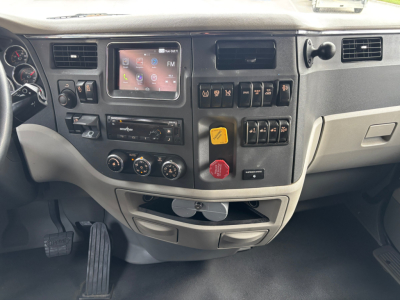 Peterbilt 579 dash view showing touchscreen infotainment, control switches, and gauges.