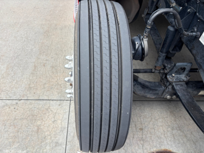 Peterbilt 579 front wheel and suspension area showing vertical dual tires and mechanical components.
