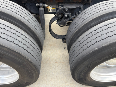 Peterbilt 579 chassis view showing tandem rear axles and suspension components; dual tires and air ride bellows visible.