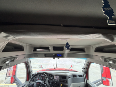 Truck cab interior view from forward looking camera showing steering wheel, dashboard, rearview mirrors, and overhead console. No legible labels visible.