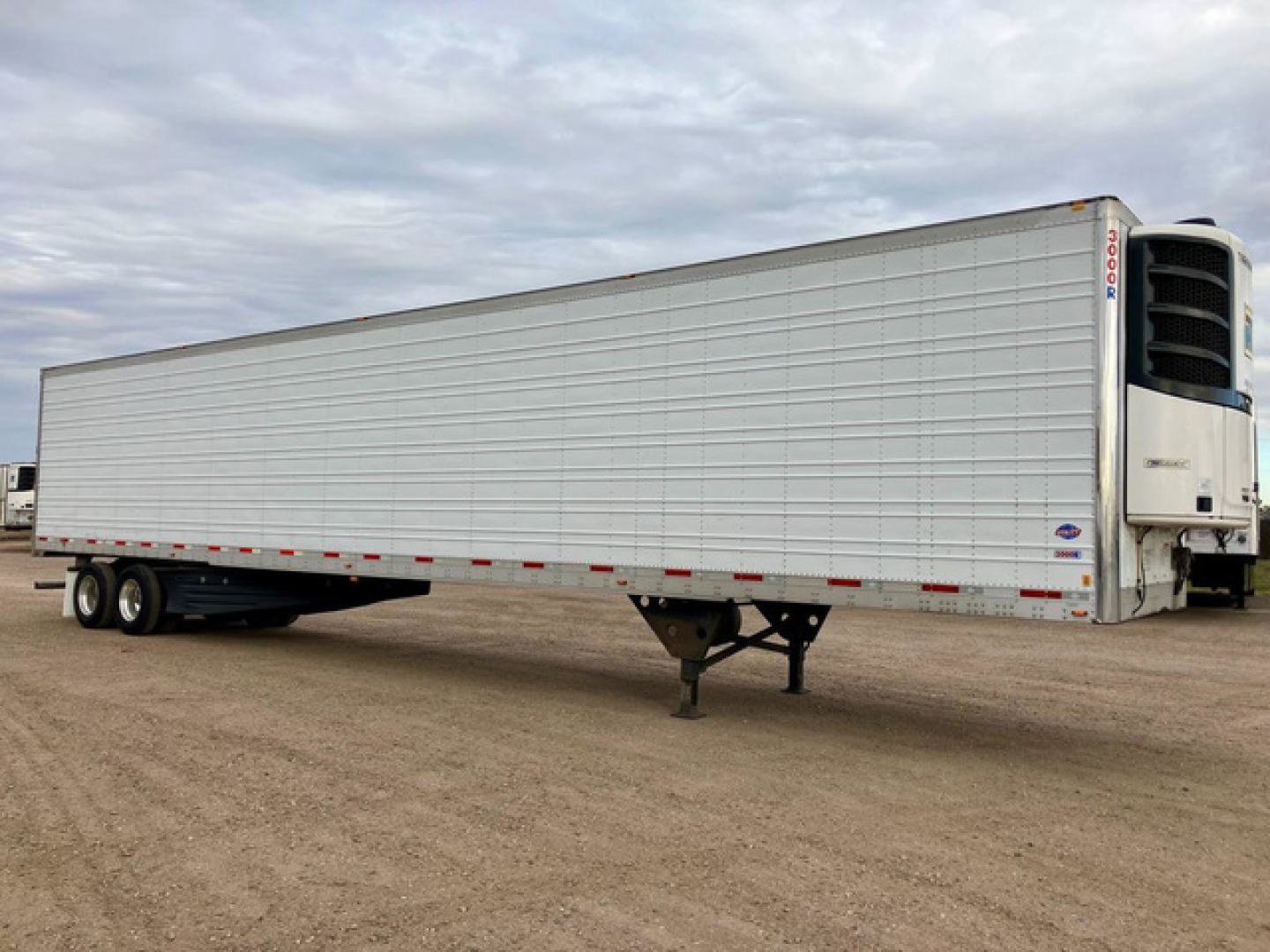 Trailer side view showing a 2020 Utility refrigerated trailer with a Thermo King unit at the front, white corrugated sides, and tandem rear axles.