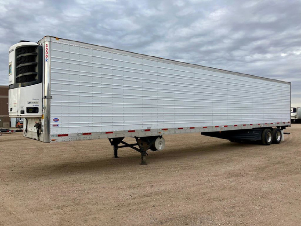 Trailer side view showing refrigerated utility trailer with large cooling unit at front, grey ribbed panels, tandem axles, and landing gear.