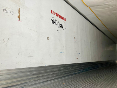 Trailer interior with white side wall and ribbed floor showing warning text 'KEEP OFF THE WALL' and THU DE logo.