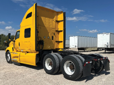 Truck cab shows a bright yellow 2022 International LT625 tractor with a high sleeper, dual rear axles, and fifth-wheel area visible.