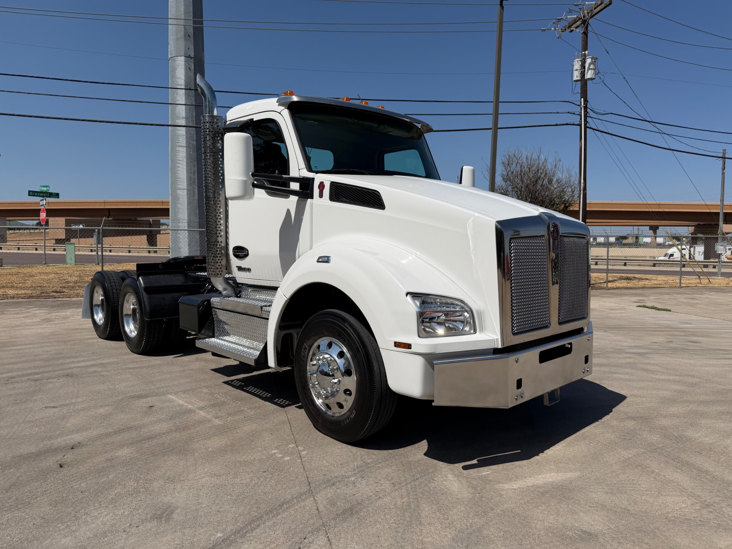 Kenworth T880 conventional daycab truck in white, front-right view showing cab, chrome grille, dual rear axles, and side steps.