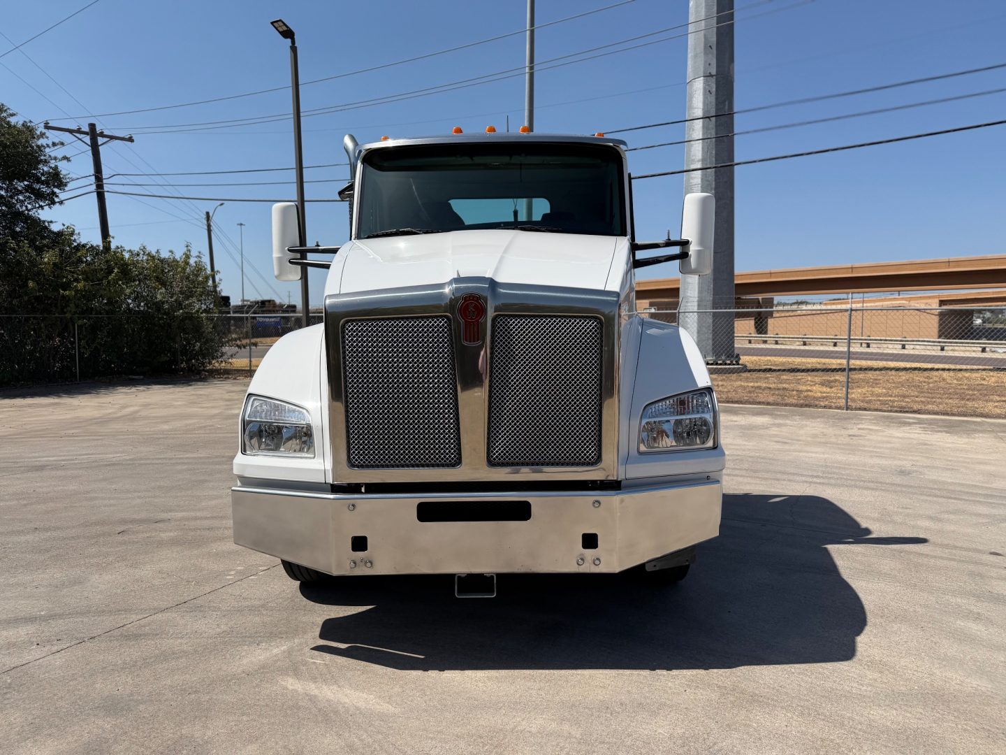 Kenworth T880 front view showing large grille, rectangular headlights, and bumper; white cab with stock number 0631422 visible; daytime outdoor lot.