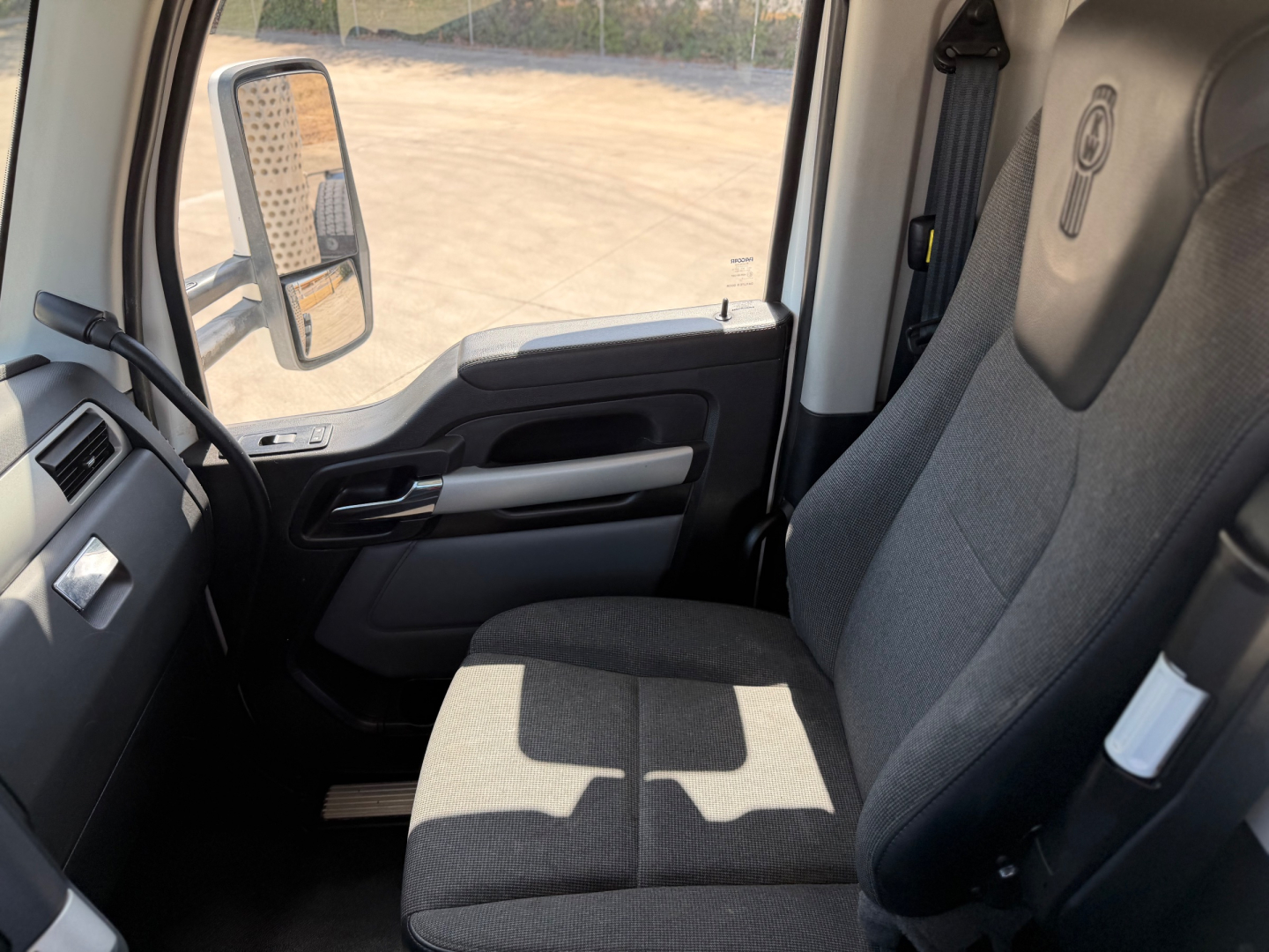 Kenworth T880 interior cab view showing driver seat and dashboard; no visible text/labels readable in image.