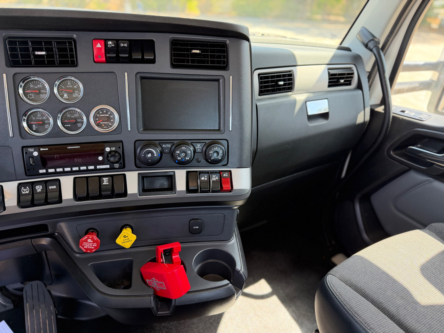 Kenworth T880 interior dashboard showing gauges and controls with ignition keys and red key tag.