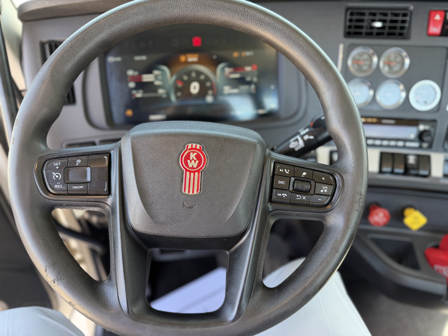 Kenworth T880 steering wheel and instrument cluster in-cab view showing steering wheel controls and dashboard gauges
