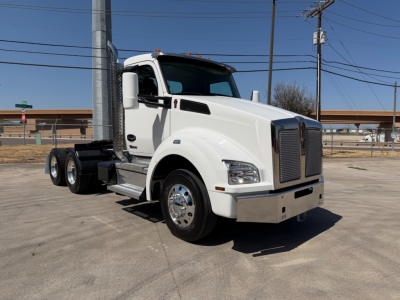 Kenworth T880 conventional daycab truck in white, front-right view showing cab, chrome grille, dual rear axles, and side steps.
