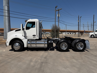 Kenworth T880 conventional daycab truck side view showing chassis and dual rear axles.